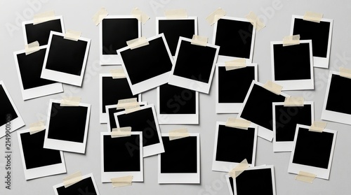 Black instant film frames taped to light grey wall background with copy space with frames attached tape scattered black composition horizontal conceptual scrapbook polaroid adhesive creative with flat