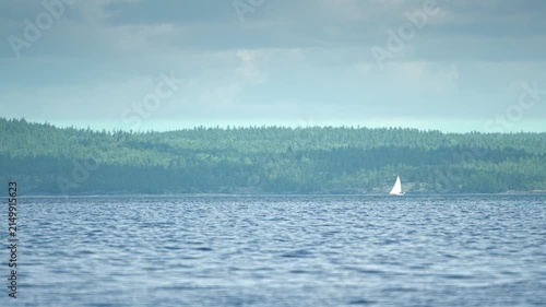 Yacht sailing past a rocky shore, time-lapse