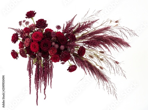 Stunning floral arrangement of deep red roses and burgundy botanical elements, including hanging amaranthus and ornamental grasses, isolated on white background