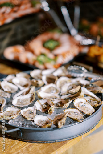 фотографія Fresh oysters on ice served on tray at seafood buffet