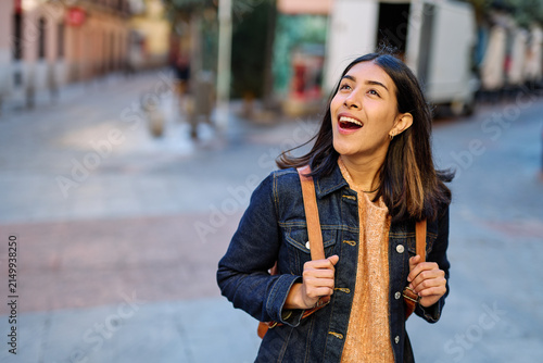 Portrait of a smiling young woman girl walking in the city, tourists visiting destination, summer trip exploring