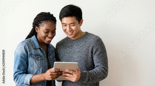 Engaged young diverse couple happily reviewing content on a tablet, symbolizing shared digital experience and modern connection