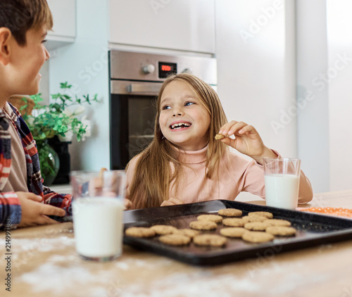 Portret of brother and sister having fun together eating breakfast in kitchen