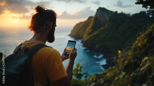 Coastal Discovery: A lone traveler with a backpack pauses on a cliff edge, phone in hand, to capture the breathtaking view of a rugged coastline meeting the turquoise sea under a warm, sunset sky.