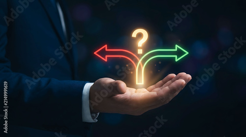 Obraz na płótnie Businessman holding glowing question mark and split arrows decision making icon