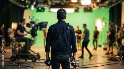 Director overseeing film production on a green screen studio set with crew and camera equipment