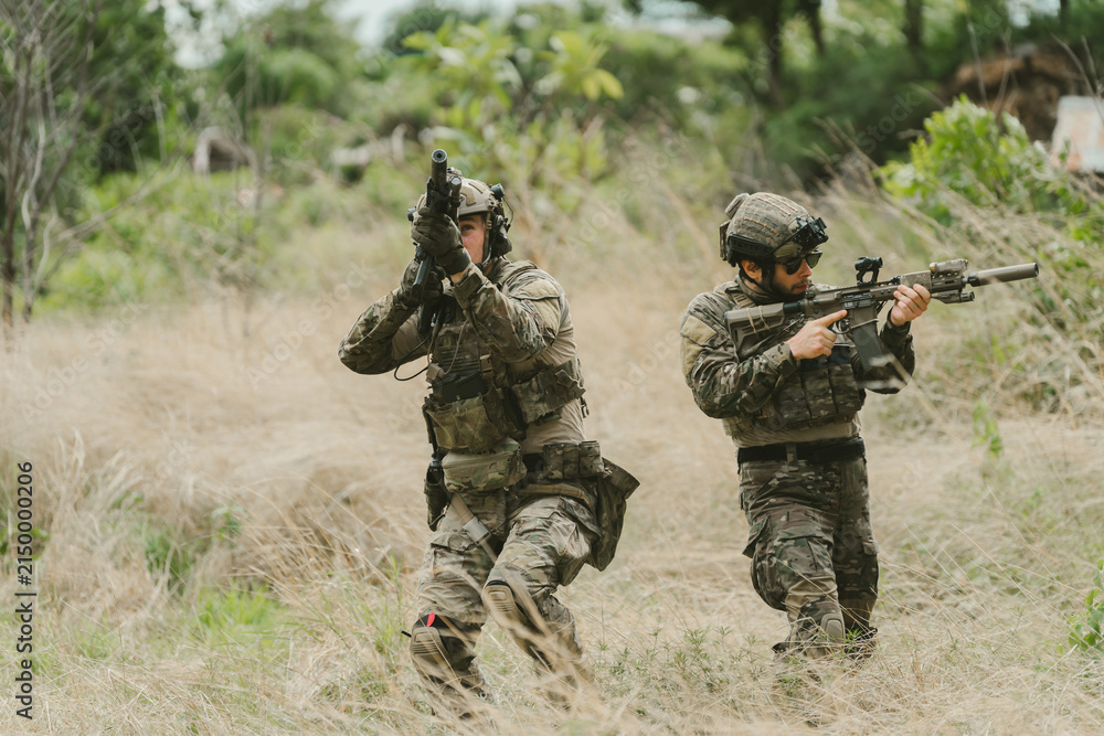 Fototapeta premium Outdoor military concept. Soldier tactical training maneuver with focus and determination, military personnel on field duty in camouflage gear with weapon and uniform