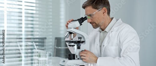 Obraz na płótnie Male scientist wearing safety glasses and lab coat