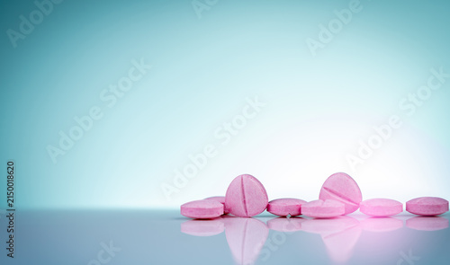 Canvastavla Pink pharmaceutical tablets on reflective surface, healthcare background