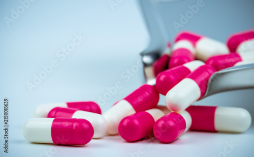 Konstfotografi Close up of pink and white pharmaceutical capsule medication on stainless steel pharmacy dispensing tray for healthcare, hospital, prescription drug and pharmaceutical industry concepts