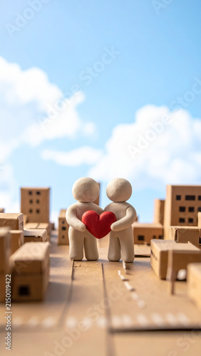 Two Genderless Clay Figures Holding a Red Heart Together