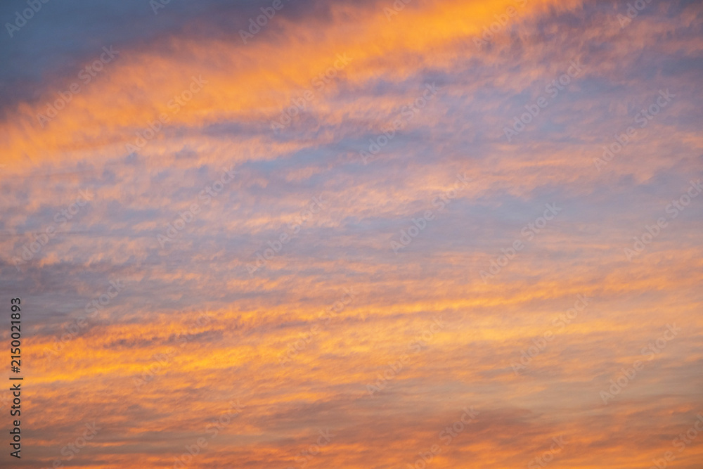 Obraz premium Dramatic sunset sky with orange and purple clouds. Golden hour light illuminating heaven.
