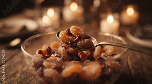 Blur effect with spoon holding dried fruit over glass bowl