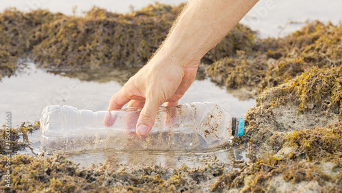 Cuadro en lienzo environmental cleanup, an environmentalist hand picking up a plastic bottle in s