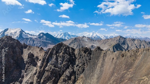 Canvas Print Hiking through Kyrgyzstan's high altitude mountains with snow capped peaks aroun