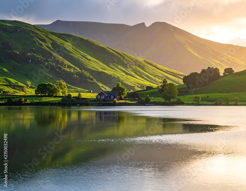 Serene mountain lake with lush green hills and misty peaks.