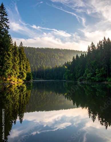 Serene river flowing through lush green forest valley.