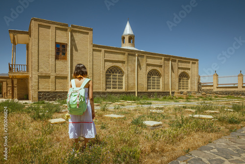 Canvastavla A girl with a backpack and a white dress stands in the courtyard of the historic Stephen Gregory Church in Hamedan, Iran