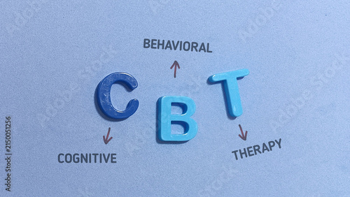 Conceptual flat lay image featuring colorful plastic letter blocks spelling CBT with handwritten annotations explaining Cognitive Behavioral Therapy.