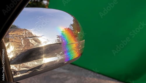 Abstract prism refracting light into rainbow spectrum on green background.
