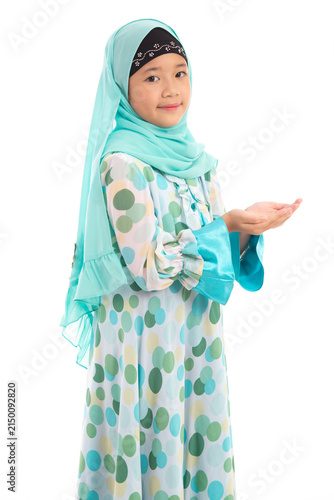 Half length portrait of cute young Asian Muslim girl praying with open hands looking at camera isolated on white background.