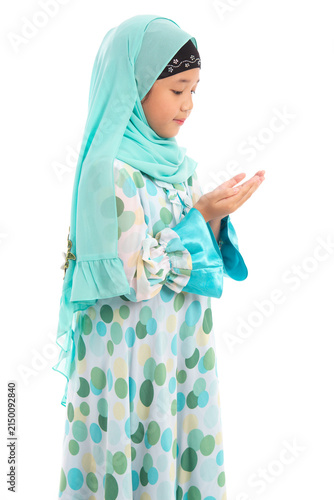Side view portrait of cute young Asian Muslim girl praying with open hands isolated on white background.