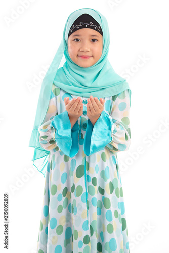 Half length portrait of cute young Asian Muslim girl praying with open hands isolated on white background.
