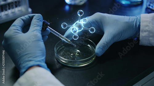 Scientist in gloved hands dropping liquid into petri dish with glowing molecule hologram.