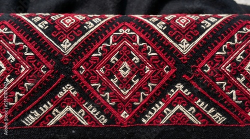 Traditional ukrainian embroidery with red and white geometric patterns on black fabric