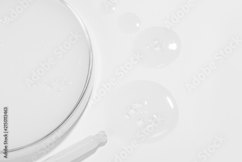 Glass Pipette Dispensing Drops of Milky White Gel near Petri Dish