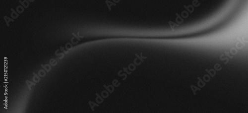 Monochrome abstract grey smooth gradation on black background with grainy noise texture.