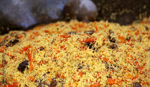 Large pot of rice mixed with meat and vegetables cooked in a traditional way at a food market
