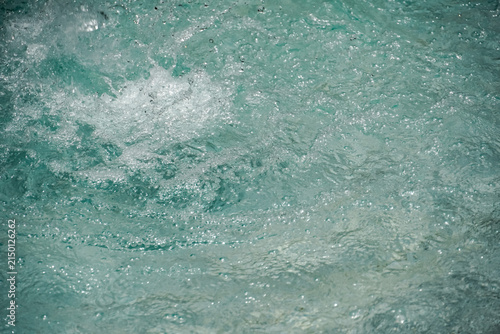 Obraz na plátně Close-up view of turbulent turquoise water with many small bubbles