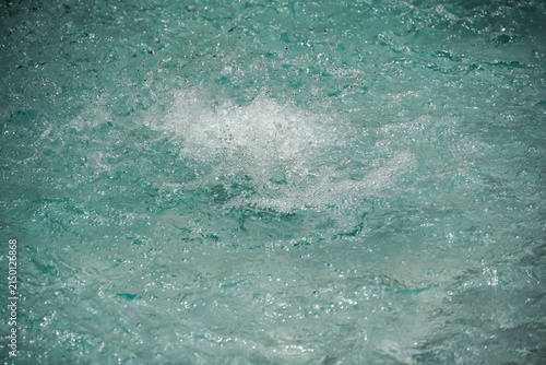 Obraz na płótnie Close-up view of turbulent turquoise water with white foam and bubbles