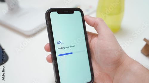Hand holding smartphone with parcel tracking app showing loading and error message