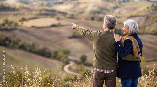 Senior couple standing outdoors looking at scenic landscape