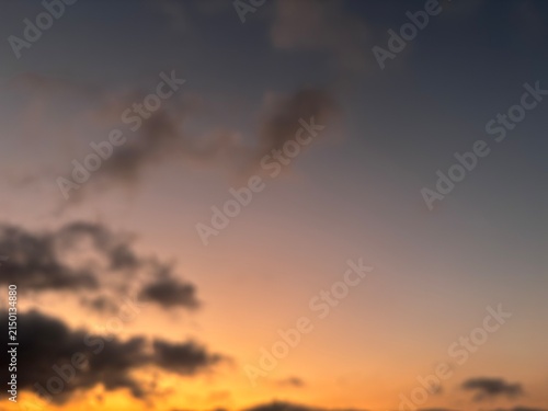 Out of focus twilight sky with glowing orange light. Soft blurred natural gradient texture for moody background and aesthetic design overlay.