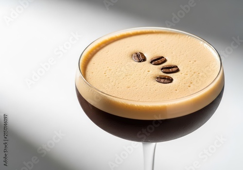 A chilled espresso martini in a glass, featuring a thick layer of velvety foam on top and decorated with three dark roasted coffee beans, coffee, martini, still-life