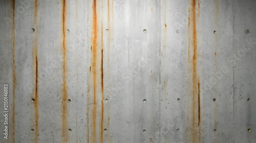 Industrial raw concrete wall texture with orange rebar rust stains and circular pockmarks