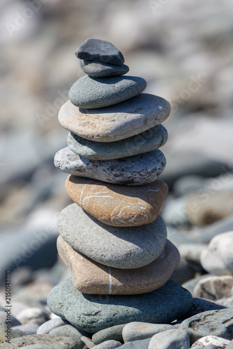 Photography Tall balanced rock stack on sandy shore