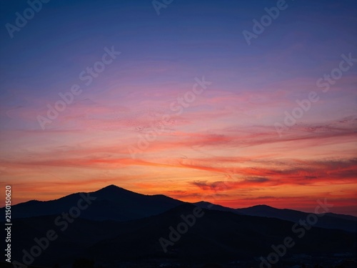 Vibrant sunset clouds over mountain silhouettes