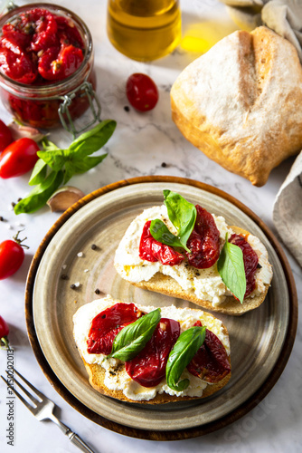 Cuadro en lienzo Open sandwiches or bruschetta with cream cheese and sun dried tomatoes on a stone table