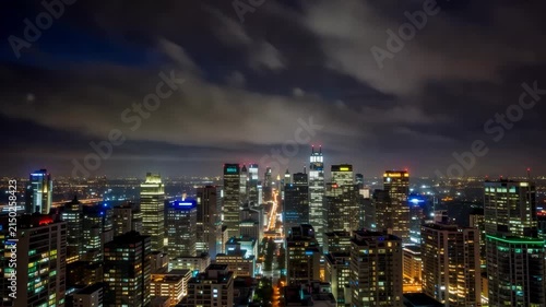Night skyline of a modern city with illuminated skyscrapers and clouds