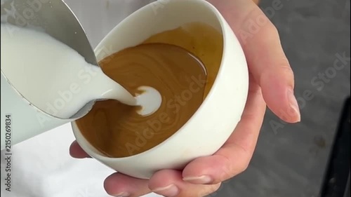 Close-Up of Barista Pouring Steamed Milk into Espresso to Create a Winged Multi-Heart Latte Art Pattern