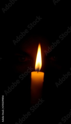 Flickering candlelight illuminates a pair of dark, mysterious eyes surrounded by shadows, ||eyes, intrigue