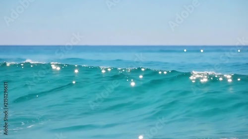 Clear turquoise ocean waves breaking in bright sunlight