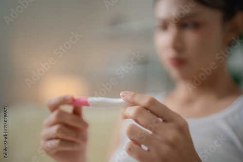 Bild auf Leinwand Pregnancy test and reproductive health concept with a woman holding a home test