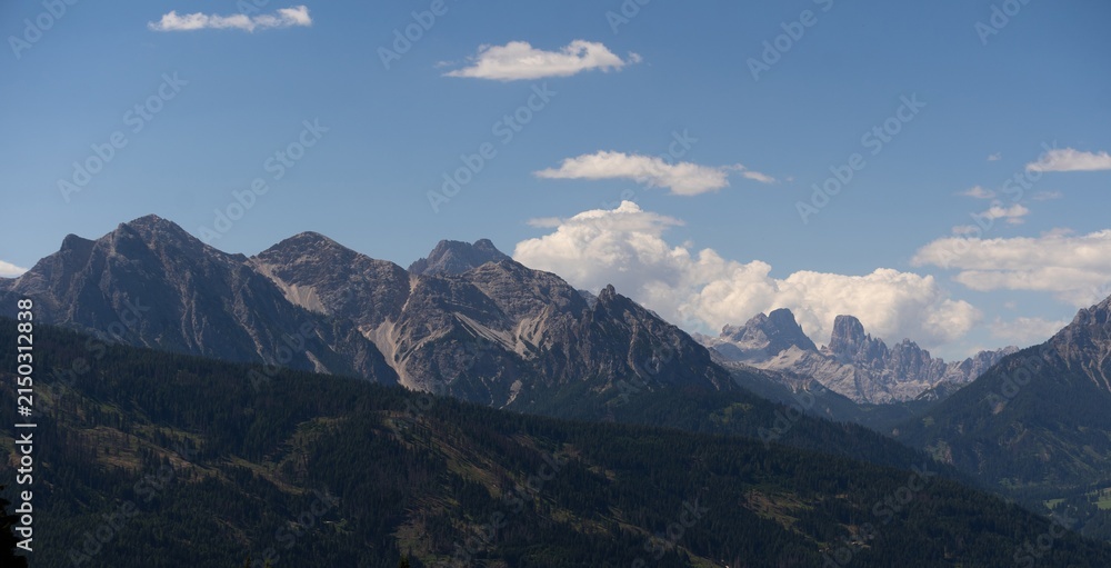 Obraz premium Majestic scenery of rough mountain ridge near grassy hills