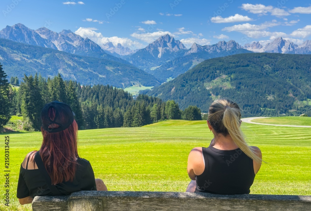 Obraz premium Tourists sitting on a bench overlooking the mount