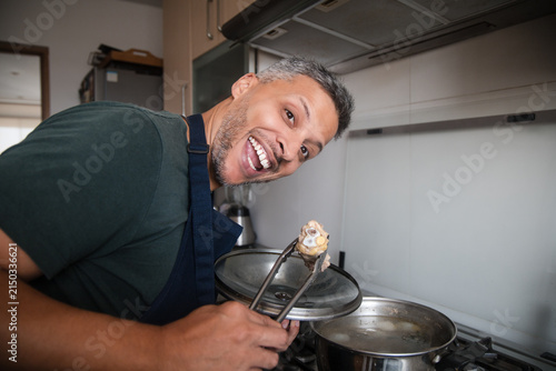 Man Laughing While Cooking Homemade Soup